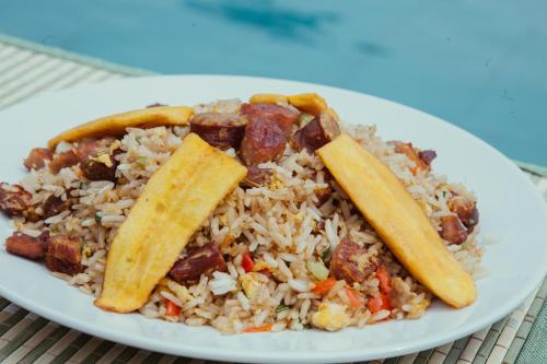 a white plate of food with rice and meat and vegetables at Maloca Inn in Sauce