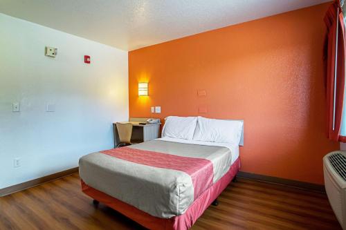 a bedroom with a bed with an orange wall at Motel 6-Prescott, AZ in Prescott
