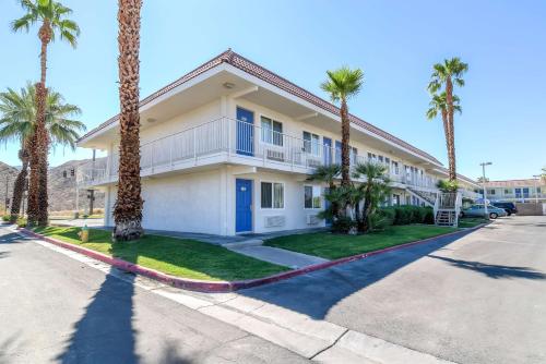 a house with palm trees in front of a street at Motel 6-Rancho Mirage, CA - Palm Springs in Rancho Mirage