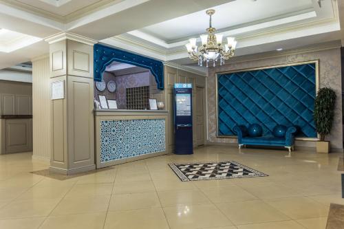 a lobby with a blue wall and a blue couch at Grand Sapphire Hotel in Almaty