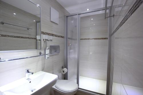 a bathroom with a shower and a toilet and a sink at Hotel Europäischer Hof in Elsterwerda