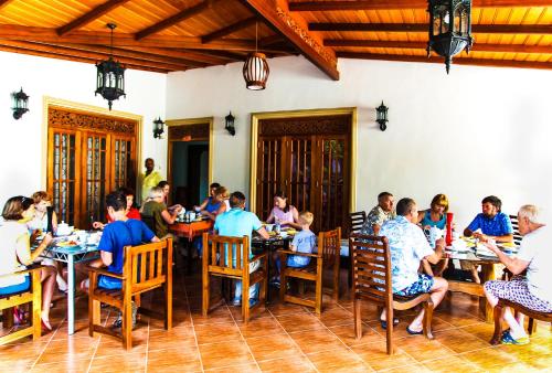a group of people sitting at tables in a restaurant at Green View Holiday Resort in Kandy
