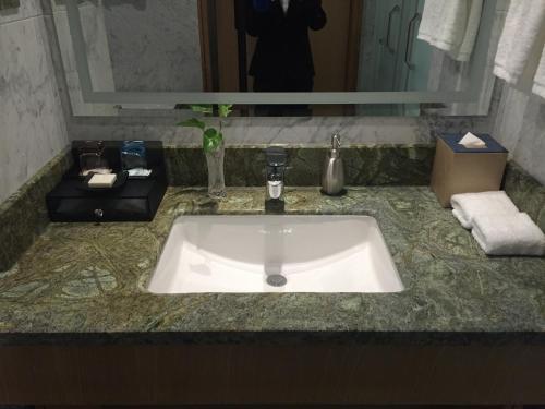a bathroom counter with a sink and a mirror at Wyndham HangZhou East in Hangzhou