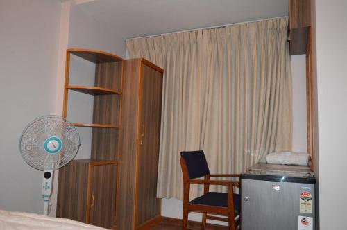 a bedroom with a bed and a fan and a chair at k2Homes in Pātan