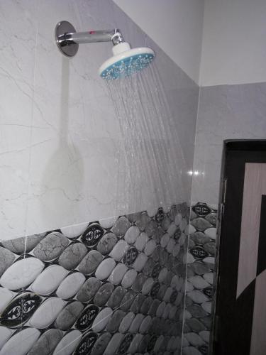 a shower with a shower head in a bathroom at Friends Home Stay - Agra in Agra