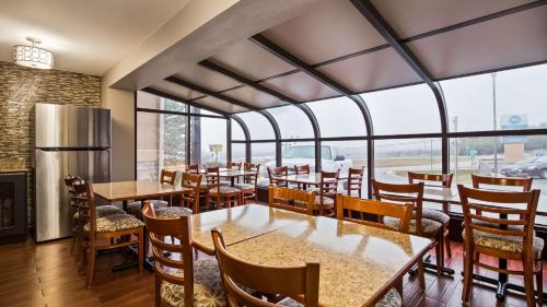 a restaurant with tables and chairs and a large window at Best Western Coachlight in Rolla