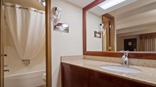 La salle de bains est pourvue d'un lavabo et d'un miroir. dans l'établissement Best Western Montis Inn, à St. Robert