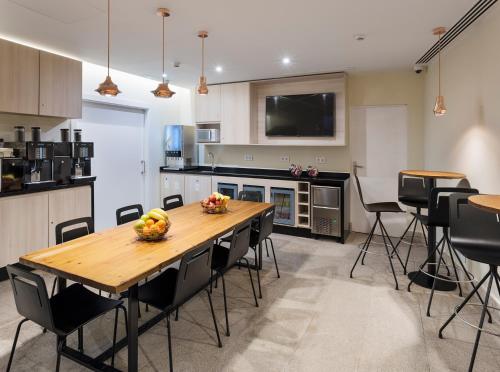 a kitchen with a wooden table and black chairs at B&B HOTEL Madrid Centro Puerta del Sol in Madrid