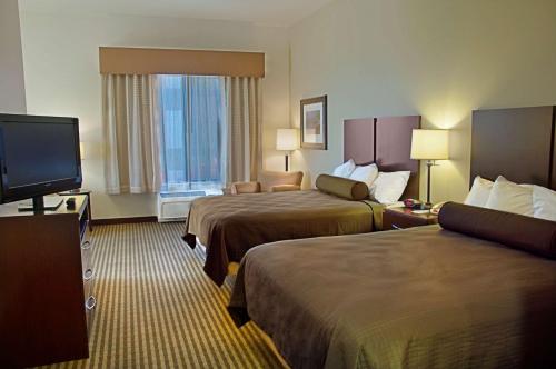 Legacy Inn & Suites في ميسا: غرفة فندقية بسريرين وتلفزيون بشاشة مسطحة