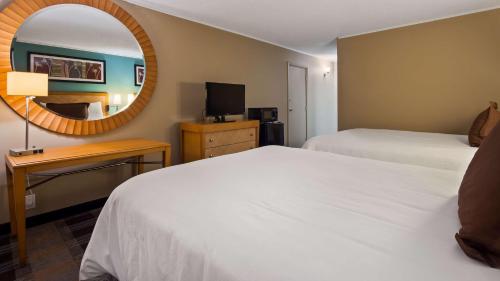 a hotel room with two beds and a mirror at SureStay Plus Hotel by Best Western Jasper in Jasper