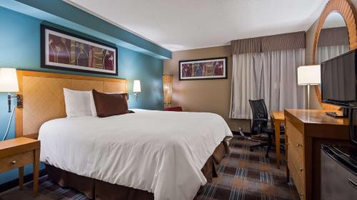 a hotel room with a bed and a desk at SureStay Plus Hotel by Best Western Jasper in Jasper