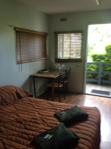 a bedroom with a bed and a table and a desk at Riverside Tourist Park in Rockhampton
