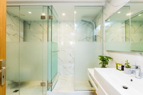 a bathroom with a glass shower and a sink at Menta City Boutique Hotel in Rethymno