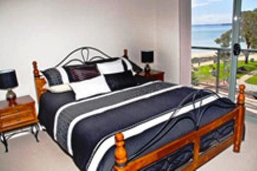 a bedroom with a bed with a view of the ocean at Boardwalk By The Beach in Rockingham
