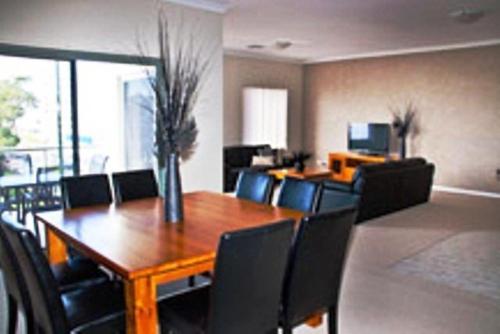 a dining room with a wooden table and chairs at Boardwalk By The Beach in Rockingham