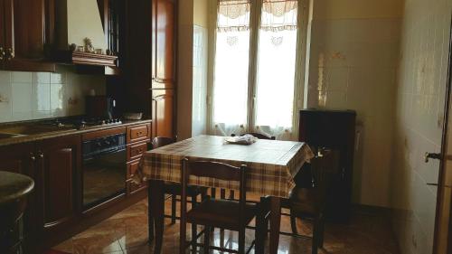 ドルガーリにあるAppartamento Dorgaliのキッチン(テーブル、椅子付)、窓