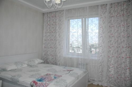 ケメロヴォにあるApartment na Sportivnaya 17/1のベッドルーム1室(ベッド1台付)、窓(カーテン付)