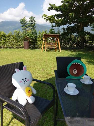 a teddy bear sitting on a bench next to a table at Elizabeth Bed and Breakfast in Fengli