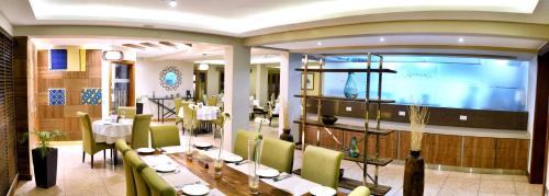 a dining room with a long table and green chairs at The Zehneria Hotel in Nairobi