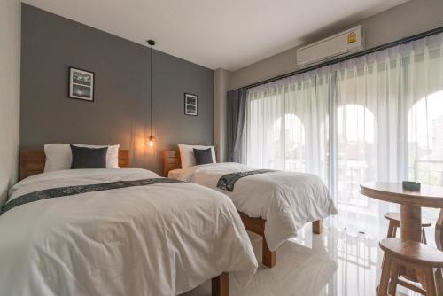 a bedroom with two beds and a window at The Besavana Phuket - SHA Extra Plus in Phuket Town
