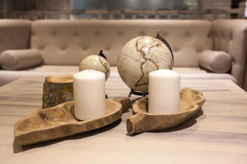 a table with two candles and a globe on it at Hotel Luze El Toro in Berrioplano