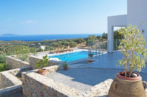 a villa with a swimming pool and a view of the ocean at Evgoro Luxury Suites in Agia Galini