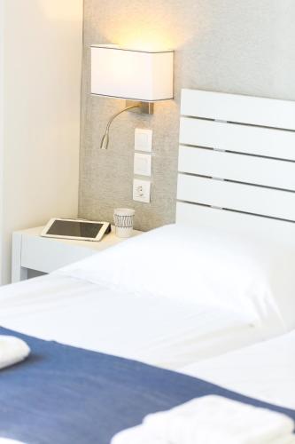 a bedroom with a bed and a desk with a lamp at Meltemi Coast Suites in Rethymno Town