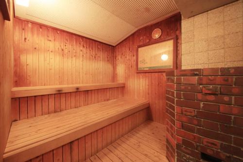 a room with a sauna with a brick wall at Kasuga no Mori in Saku