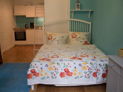 a bedroom with a white bed with flowers on it at Schönes Apartment Blau zentral in Bremen