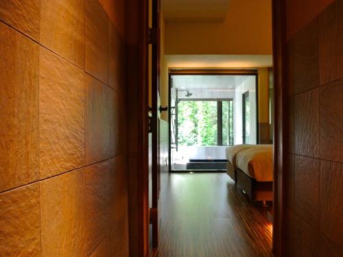 a bedroom with a bed and a door leading to a doorway at Kunugi Relaxation with 4 modern rooms in Hakuba