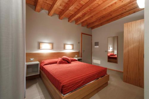 CinigianoにあるLe Scuole B&B - by ColleMassari Hospitalityのベッドルーム1室(赤いシーツを使用した大型ベッド1台付)