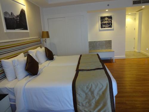 a bedroom with a large bed with white sheets and pillows at Amanora The Fern Hotels & Club in Pune