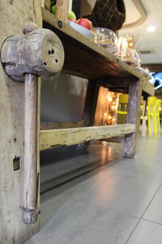 a wooden table in a restaurant with a table with food on it at Dannunziano Aparthotel in Chieti