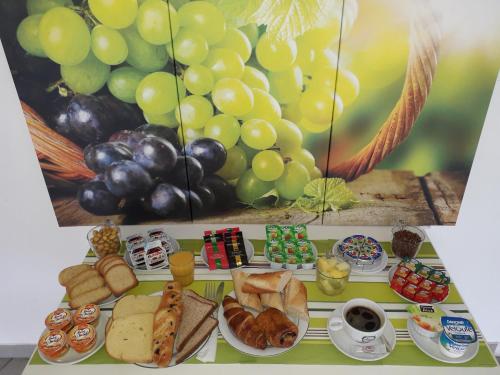 a tray filled with different types of bread and grapes at Hôtel Formules Club in Cenon