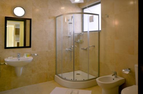 a bathroom with a glass shower and a sink at Public Security Hotel & Chalets in Aqaba