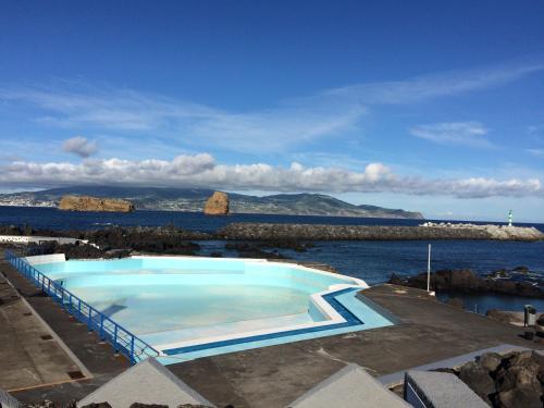 a large blue swimming pool next to the water at Villa Da Madalena in Madalena