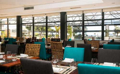 a restaurant with blue chairs and tables and windows at Hotel Pestana Cascais Ocean & Conference Aparthotel in Cascais