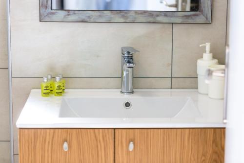 a sink in a bathroom with a mirror at Meltemi Coast Suites in Rethymno Town
