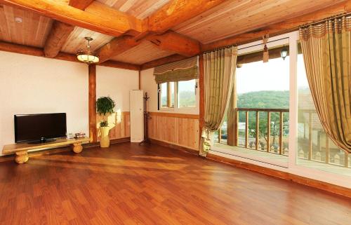 a living room with a flat screen tv and large windows at 보성녹차리조트 in Boseong