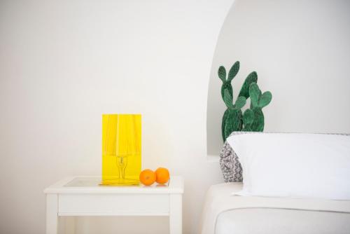 une table avec une lampe jaune et des oranges. dans l'établissement Masseria Serralta, à Locorotondo