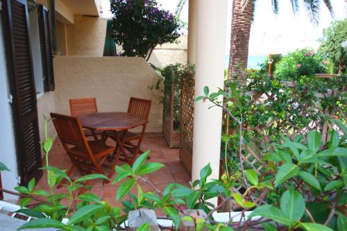 a table and two chairs on a patio with plants at Albatros in Capoliveri