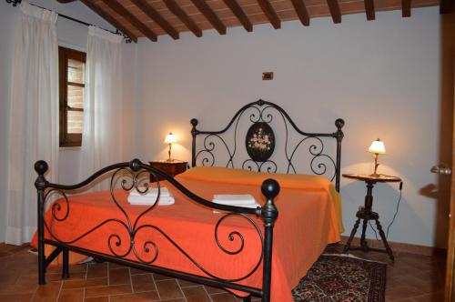 1 dormitorio con 1 cama con colcha de color naranja en Casa Vacanze Il Fornacino, en Asciano