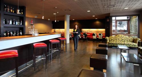 a woman standing at a bar in a restaurant at HG Alto Aragón in Formigal