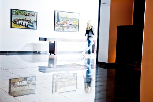 a woman walking through an art exhibit in a museum at Stord Hotel in Stord