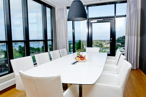 a white dining room with a white table and white chairs at Stord Hotel in Stord