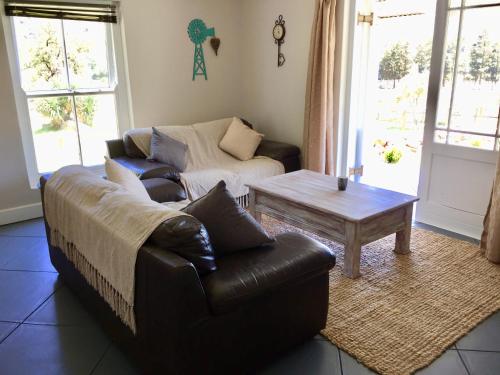a living room with a couch and a coffee table at Olive Cottage in Franschhoek