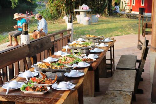 坤西育府的住宿－河&山度假村，一张长木桌子,上面放着食物盘