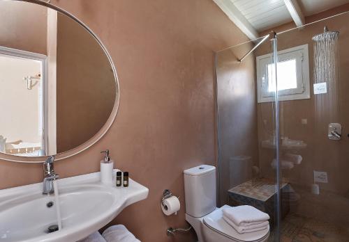 a bathroom with a sink and a mirror and a toilet at Marni Village in Hersonissos
