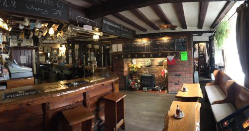 a pub with a bar with a fireplace and tables at Sorrel Horse Inn in Ipswich