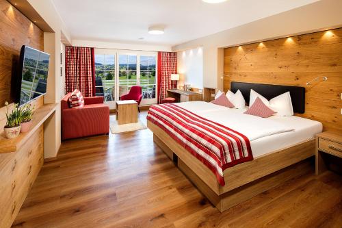 ein Hotelzimmer mit einem Bett und einem Wohnzimmer in der Unterkunft Hotel Johanneshof in Oberstaufen